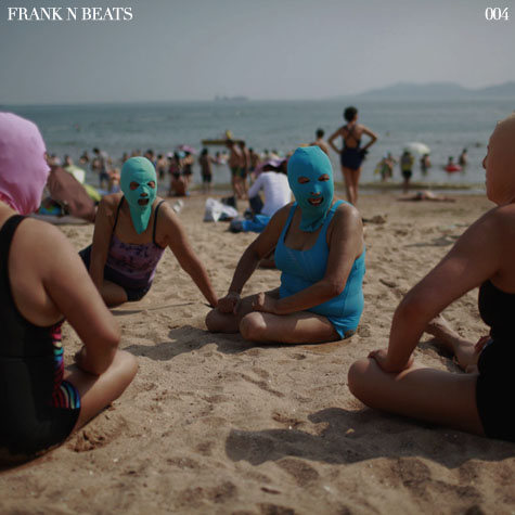 Women, wearing nylon masks, chat as they rest on the shore during their visit to a beach in Qingdao